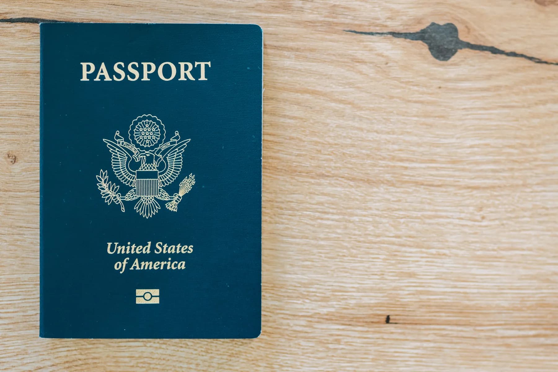 A United States passport lying on a wooden table